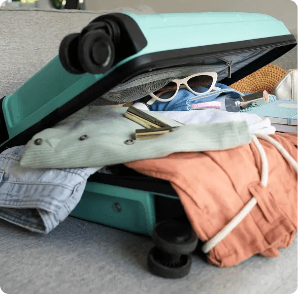 Kleidung quillt aus einem unordentlich gepackten Koffer